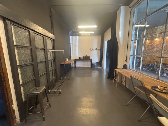 Sala de producción de Plató La Mina con mesa de trabajo, suelo de microcemento y rótulo LA MINA al fondo