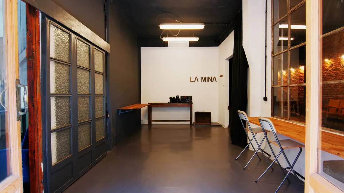 Production room at Plató La Mina with a work table and the LA MINA sign in the background
